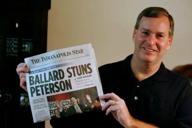 Greg Ballard holds a copy of The Indianapolis Star in 2007 with the headline "Ballard Stuns Peterson"